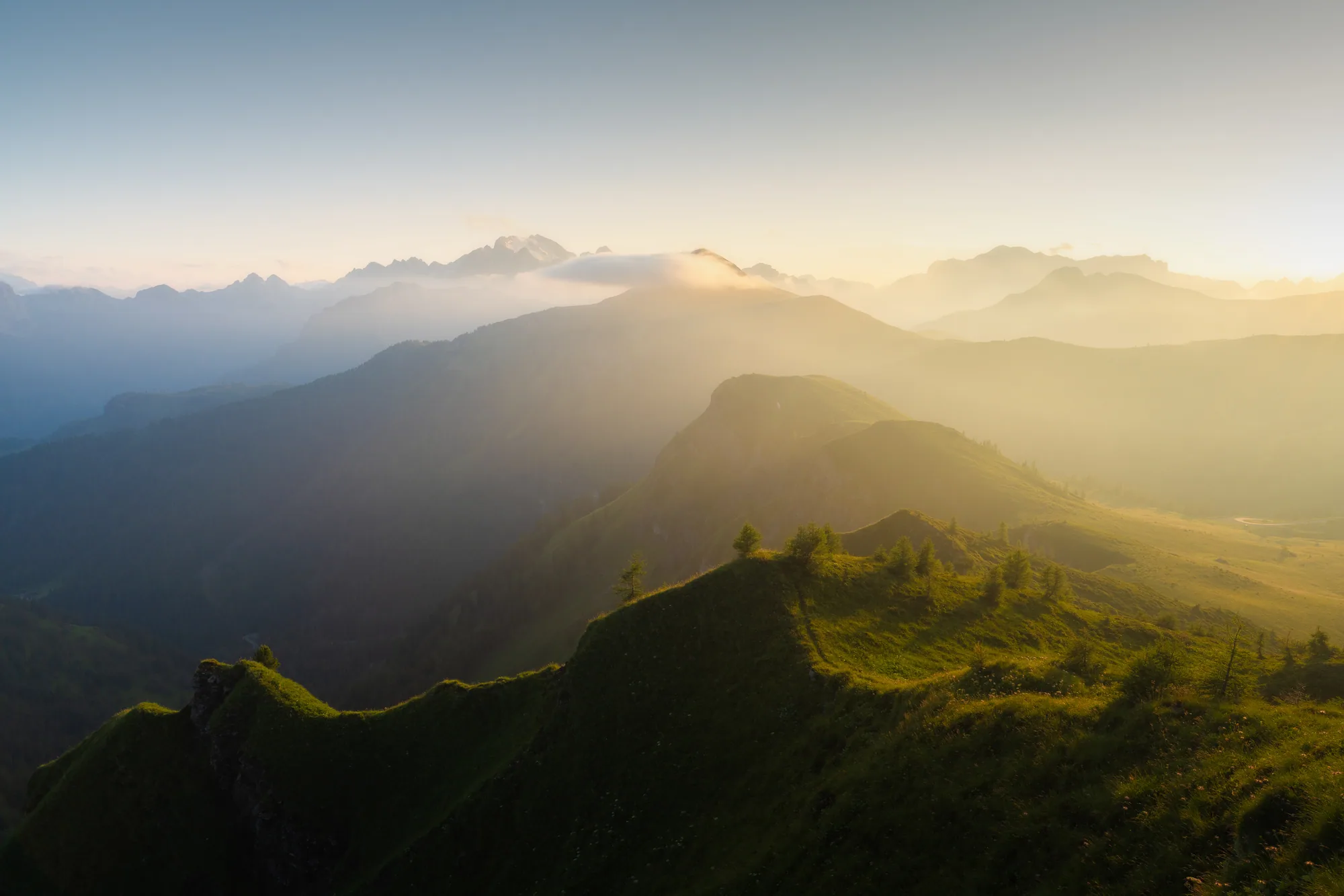 Travnatý hřeben v protisvětle s masivem Marmolady v dálce, krajinářská fotografie, fotokurz Dolomity