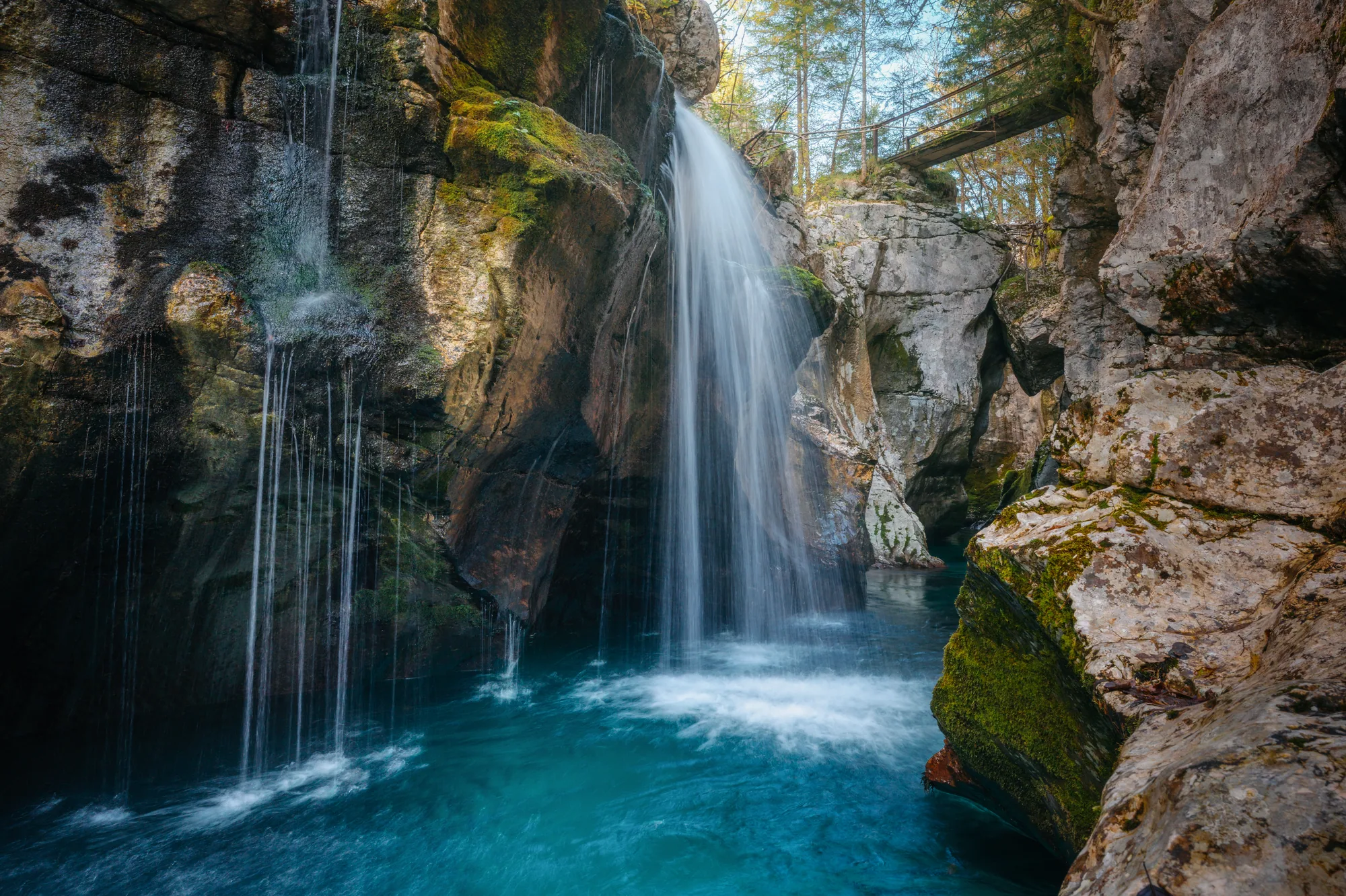 Vodopád padající do tyrkysového jezírka ve skalní soutěsce, krajinářská fotografie, fotokurz Slovinsko